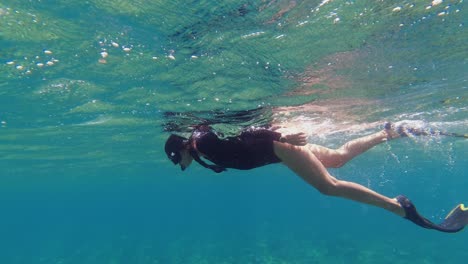 Hübsche-Frau-Mit-Zöpfen-Schwimmt-Mit-Maske-Und-Schnorchel-Im-Warmen-Wasser