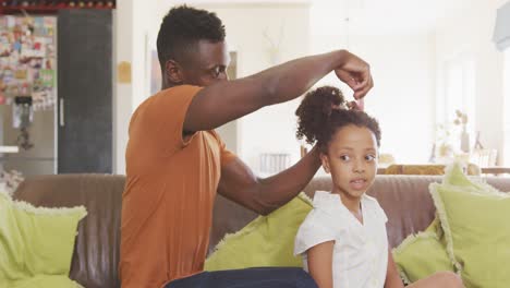 Afroamerikanischer-Vater,-Der-Seiner-Tochter-Die-Haare-Bindet