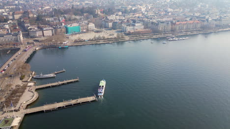 Aerial-of-Lake-Zurich-Ferry-boat-departing-from-harbor,-Zurich,-Switzerland