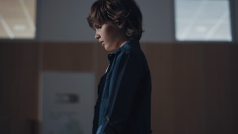 thoughtful schoolboy walking empty corridor alone. loneliness in school concept.