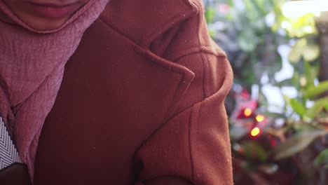 woman in a brown coat and pink scarf