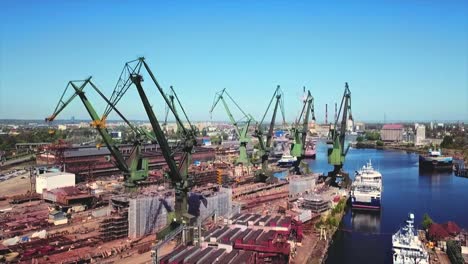 drone flying forward to cranes in the shipyard