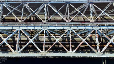 a railway bridge with a lot of metal structure, river in the background