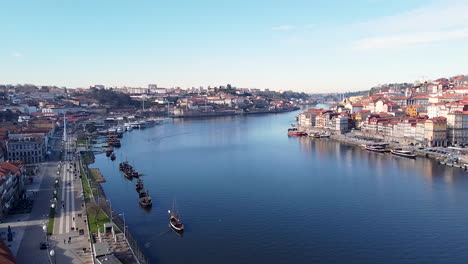 Vista-Aérea-De-Las-Orillas-Del-Río-Douro,-Gaia-Y-Oporto-En-Un-Día-Soleado,-Drone-Retrocediendo