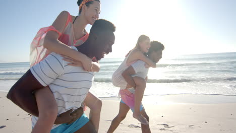 Verschiedene-Paare-Genießen-Ein-Huckepack-Rennen-Am-Strand