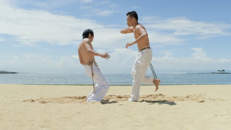 Dos-Hombres-Bailando-Capoeira-En-La-Playa