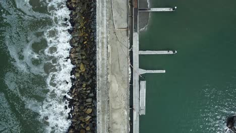 Topdown-footage-of-a-concrete-dock-built-on-a-rocky-pier