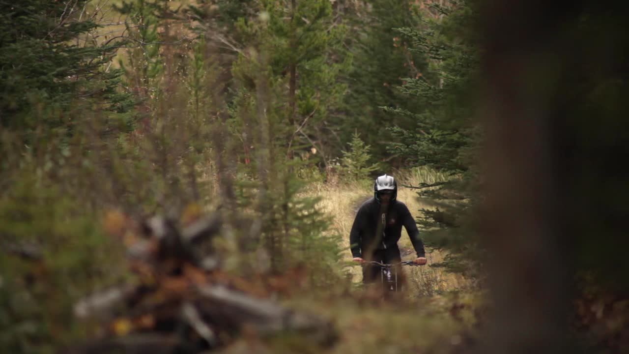 Biker rides toward the camera pan