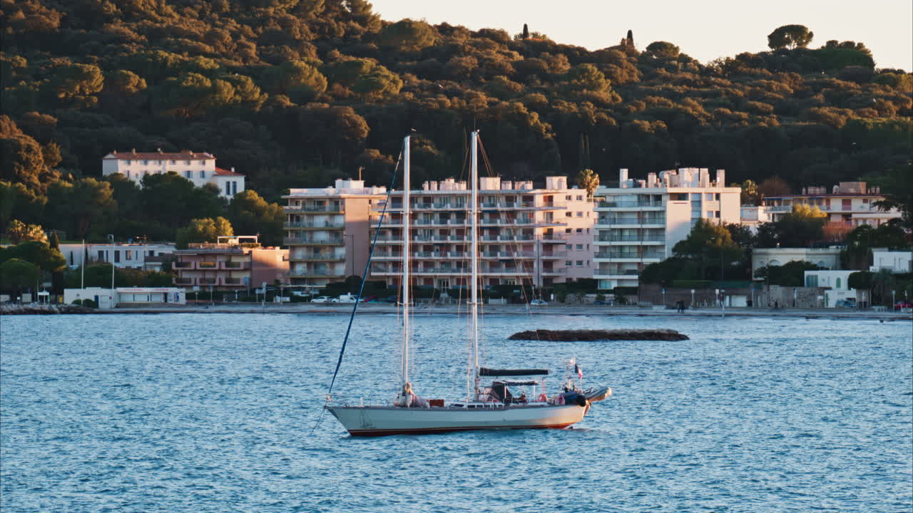 Juan-les-Pins, France - January 25, 2025: Small boat floating on the sea at sunset