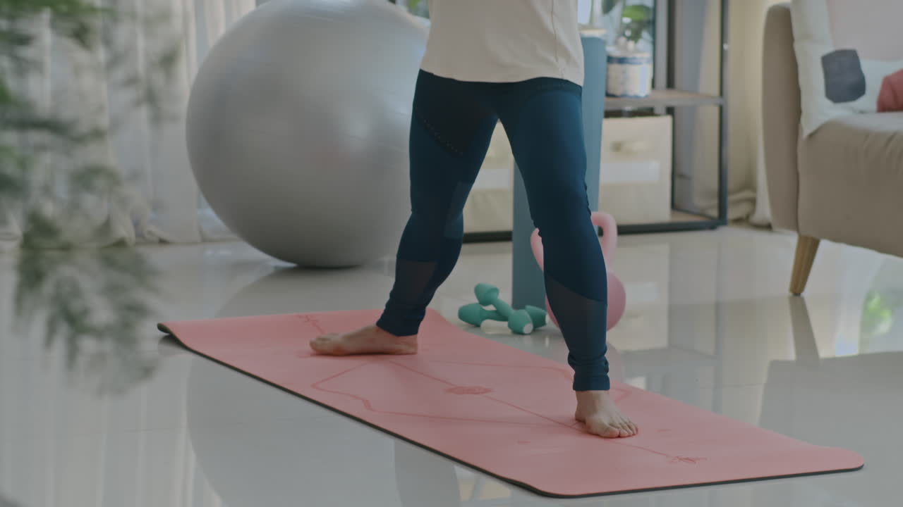 Confident Mature Woman Standing in Warrior Pose at Home
