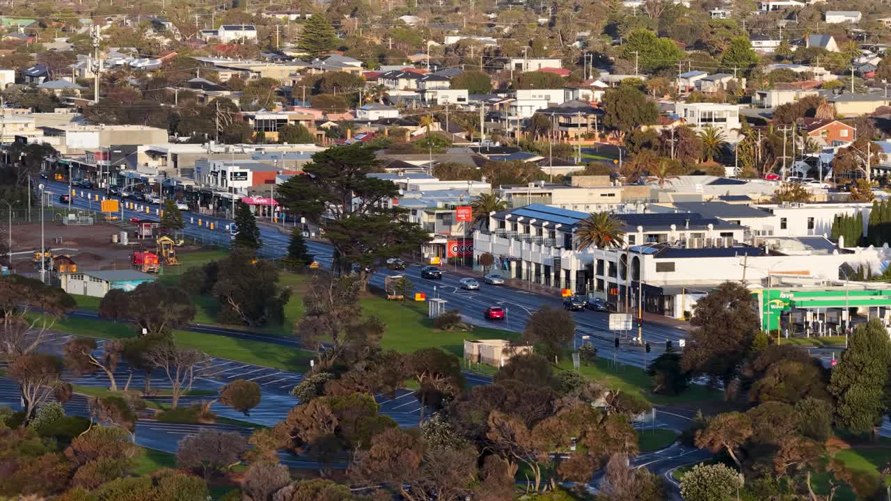 Drone camera smoothly pans above Rye’s main street, showing traffic, buildings, and green spaces