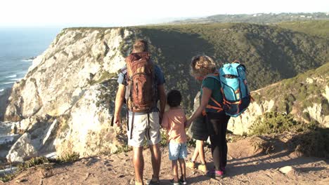 pareja de padres activos con mochilas de campamento y dos niños