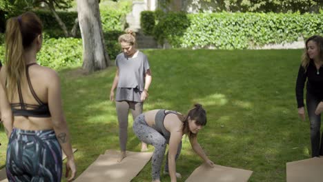 sportive people with yoga mats in park