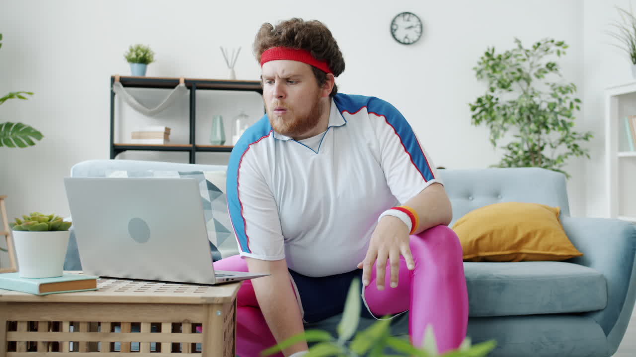 Funny Overweight Man Watching Laptop While Eating Pizza