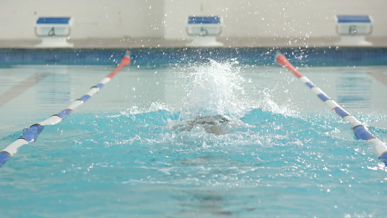 Swimmer practicing butterfly stroke in swimming pool during training session