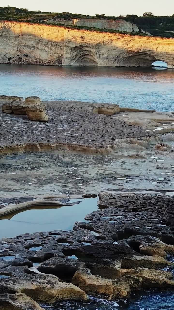 Formazioni rocciose naturali e acqua lungo la costa di Malta durante il tramonto