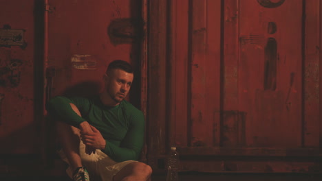 male boxer rests sitting next to the punching bag 1