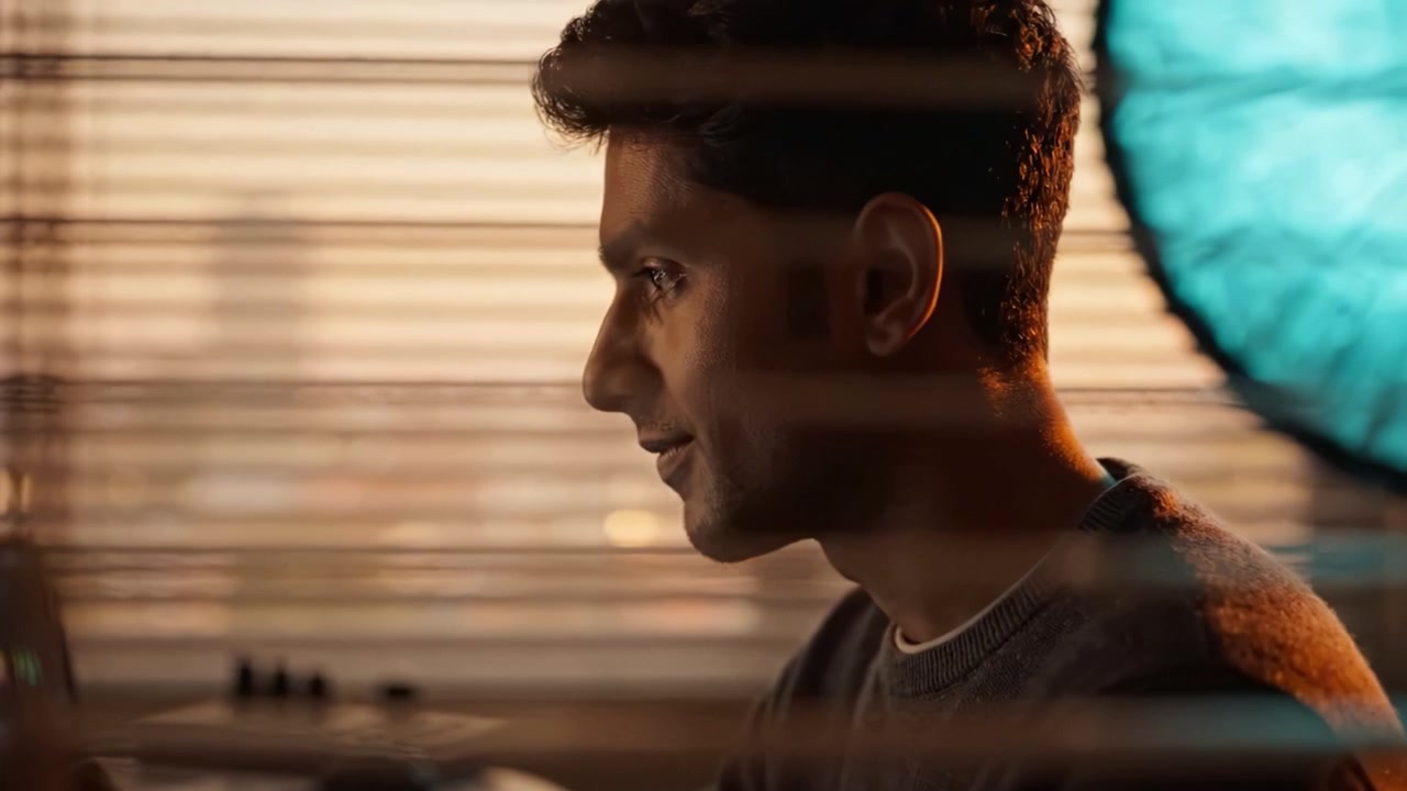 Focused Individual Engaged in Work While Illuminated by Warm Sunlight Filtering Through Blinds in a Modern Home Office Environment