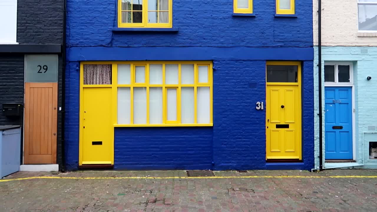 Vibrantly painted house doors within the St Luke's Mews alleyway near Portobello Road in Notting Hill, UK
