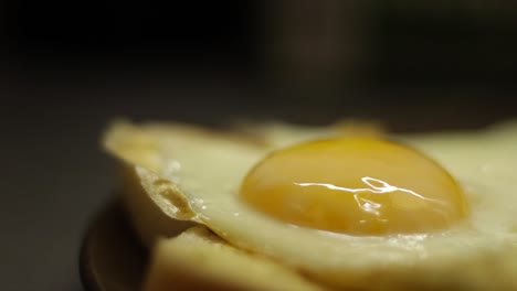 close up shot of tomato sauce being pored onto a fried egg