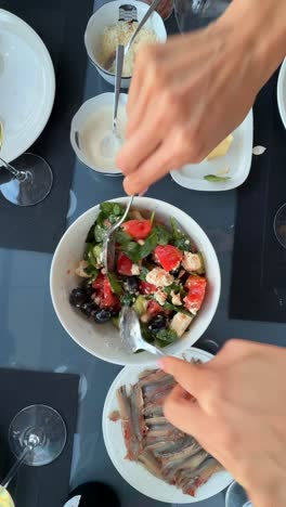 preparing a greek salad and anchovies
