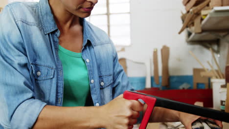 beautiful female carpenter sanding a tube