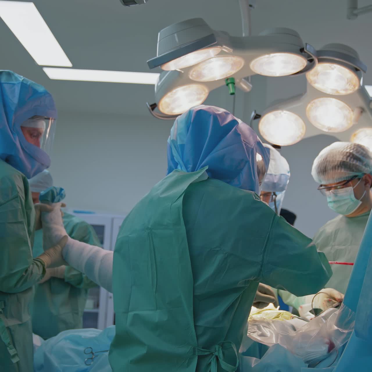 Operating room with surgery in progress. Medical team performing surgical operation in bright modern operating room
