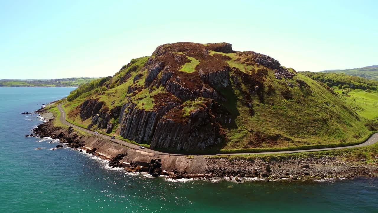 Reversing aerial video of a mountain on the Causeway Coastal Route on a bright and sunny day. Filmed in Ballygally in 4K, 60FPS and with Rec800 color.