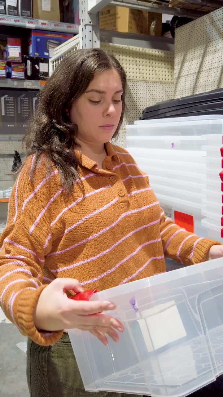 A woman is holding a clear plastic container in a store, is many different types of containers