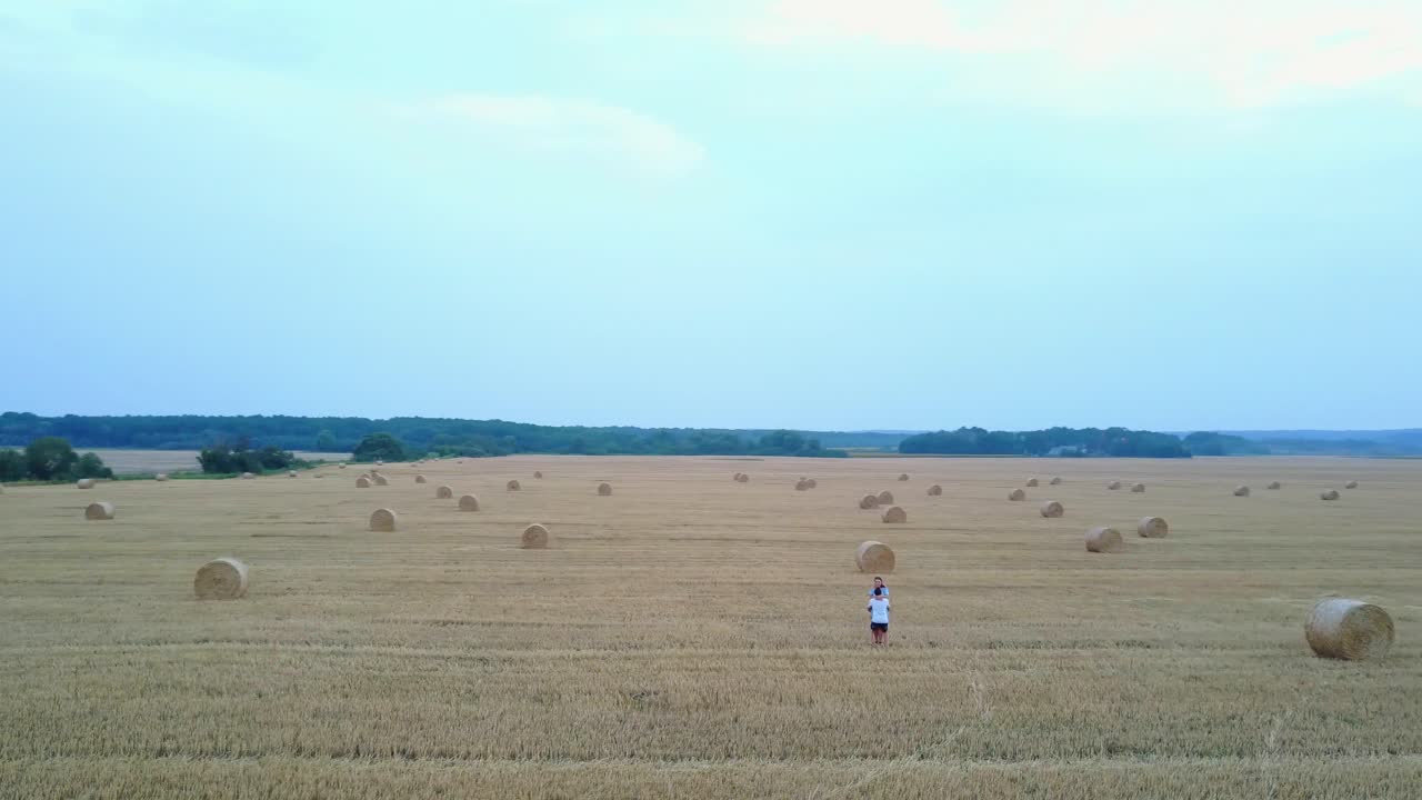 Couple Embracing Near Hay. Happy couple enjoying time in the countryside near hay bales