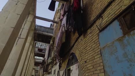 building in a dangerous ghetto with satellite dishes and laundry hanging from the balcony