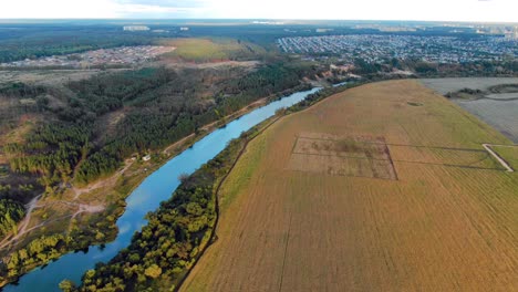 vista aérea de un río, un bosque y campos cerca de una ciudad