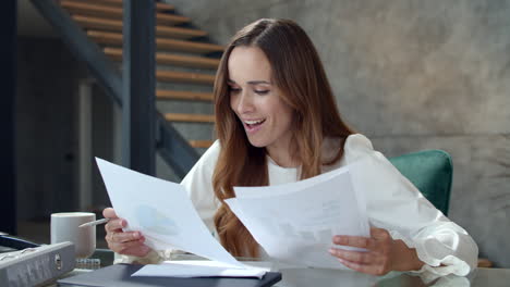 una mujer de negocios alegre analizando un informe financiero. una mujer sonriente trabajando en una oficina.