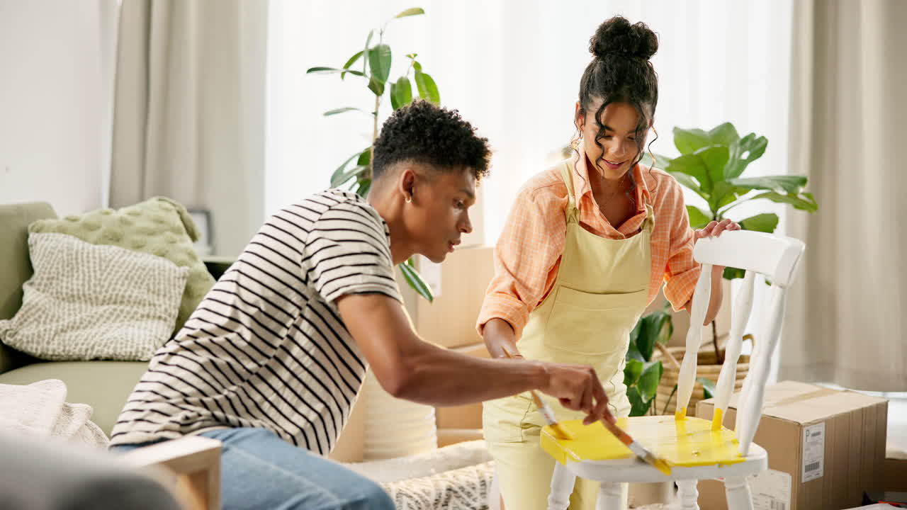 Couple painting a chair during home renovation