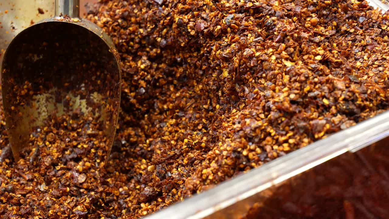 Close-up slow-motion shot of chili paddy in a plastic container on a traditional Chinese market, Chongqing. China