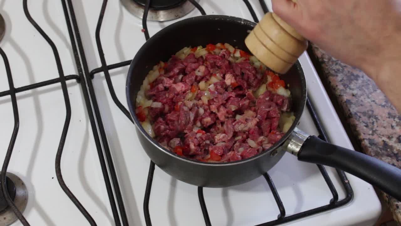 toma estática de manos condimentando carne picada con pimienta