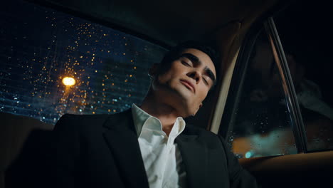sleeping man relaxing rainy window car close up. tired businessman napping alone