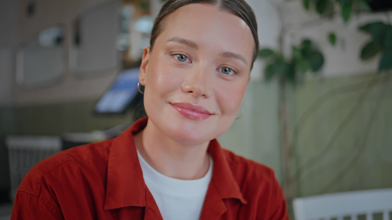 Attractive woman looking camera with smile sitting cafe table alone closeup