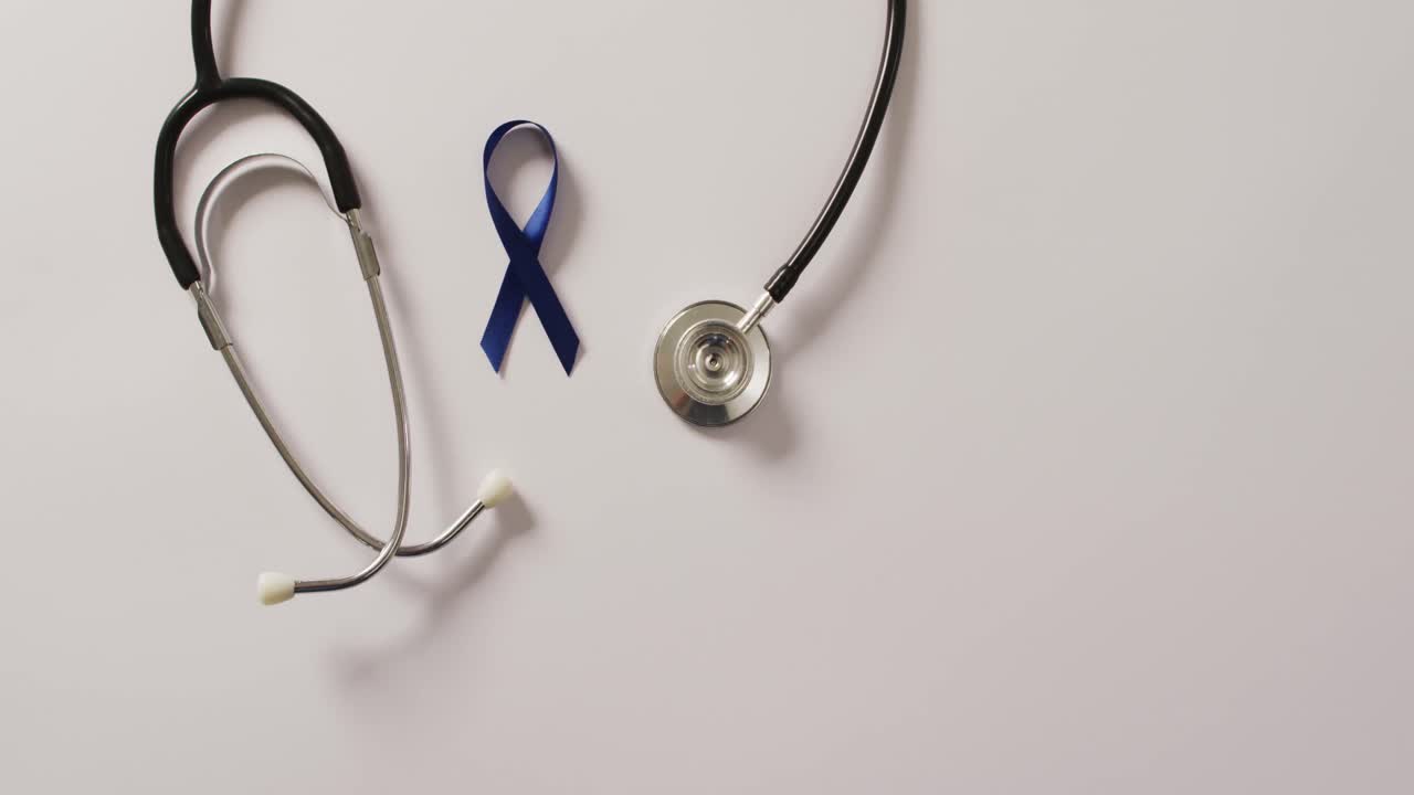 Video di stetoscopio e nastro blu scuro per il cancro al colon su sfondo bianco