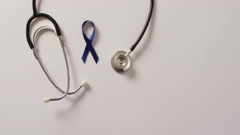 Video-of-stethoscope-and-dark-blue-colon-cancer-ribbon-on-white-background