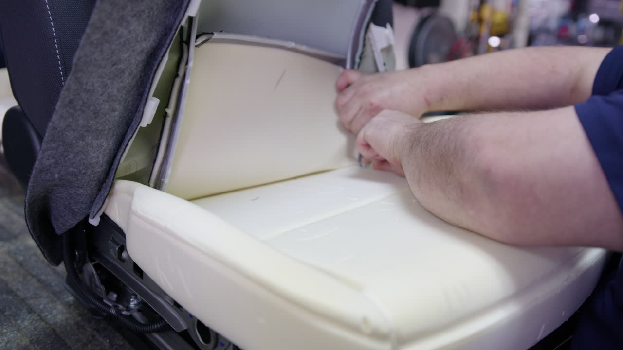 카시트의 천을 바꾸는 작업을 하는 남자