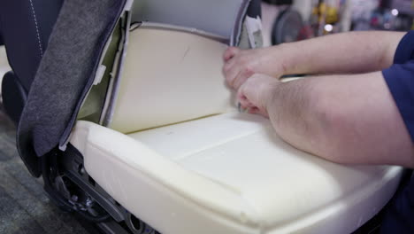 hombre trabajando en cambiar la tela en un asiento de coche
