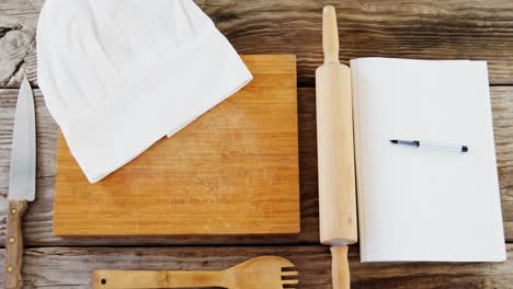 rolling pin, board, chefs cap and diary on the table