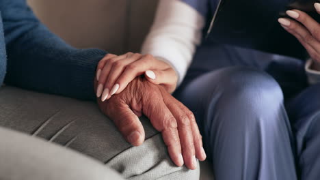 nurse holding the hand of an elderly patient