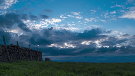 fotografía de lapso de tiempo del movimiento de la nube blanca sobre la pared de roca en goyt valley, buxton, reino unido después de la puesta del sol
