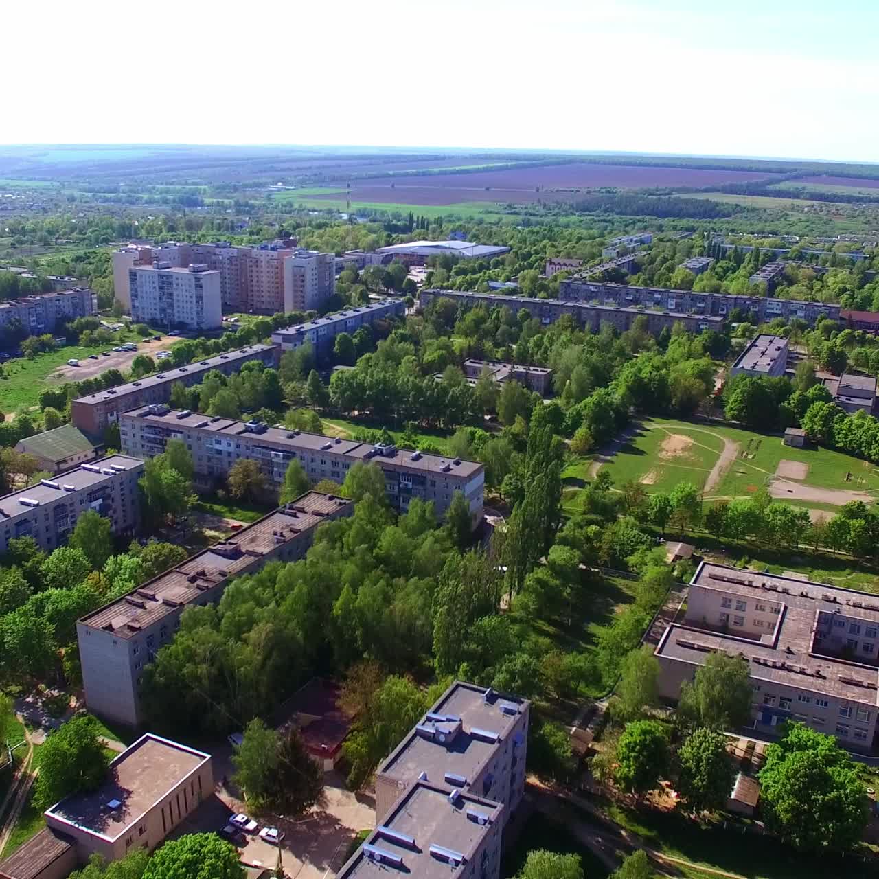 Outlook of a beautiful green city with many blocks of flats. Aerial perspective of a residential area on sunny day