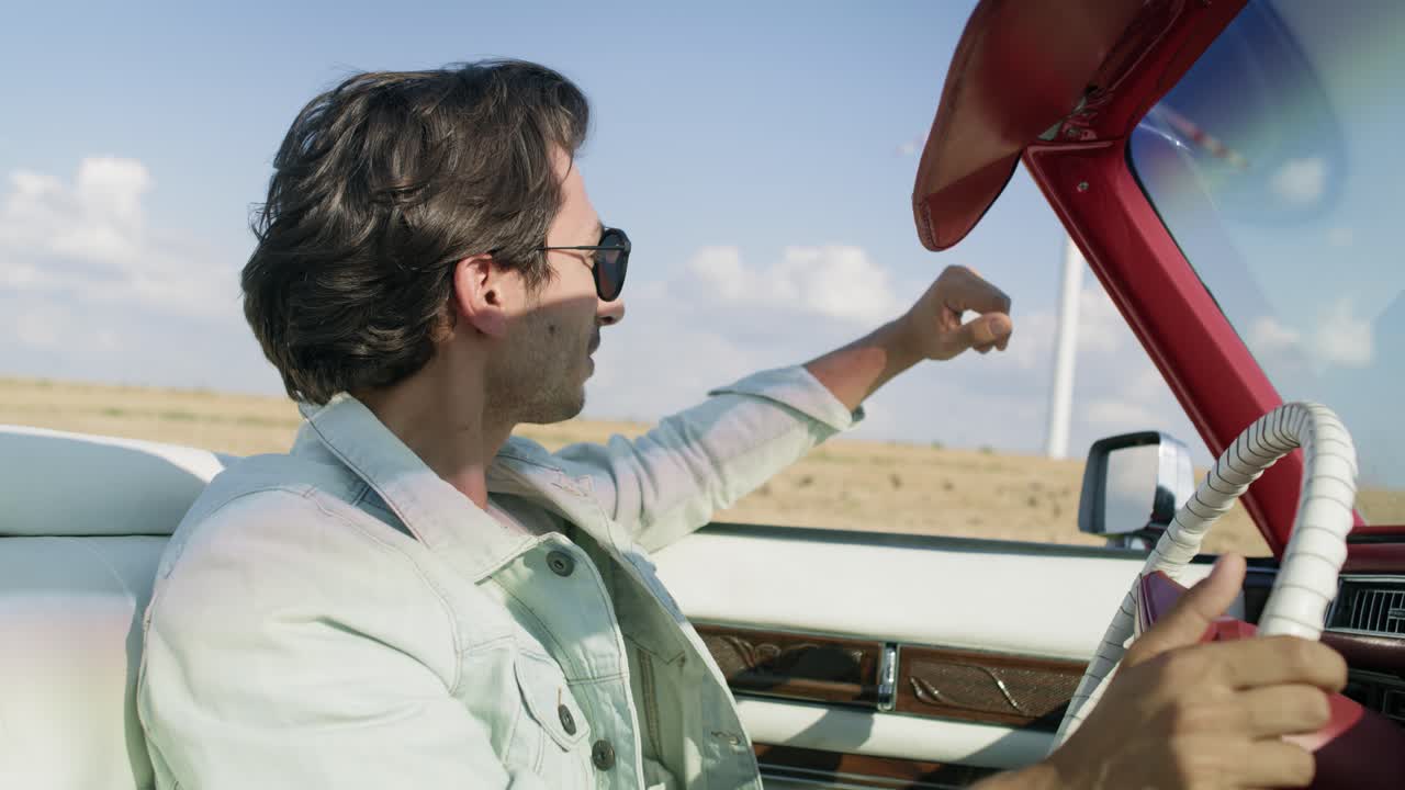 video de vista lateral de un hombre conduciendo un coche elegante