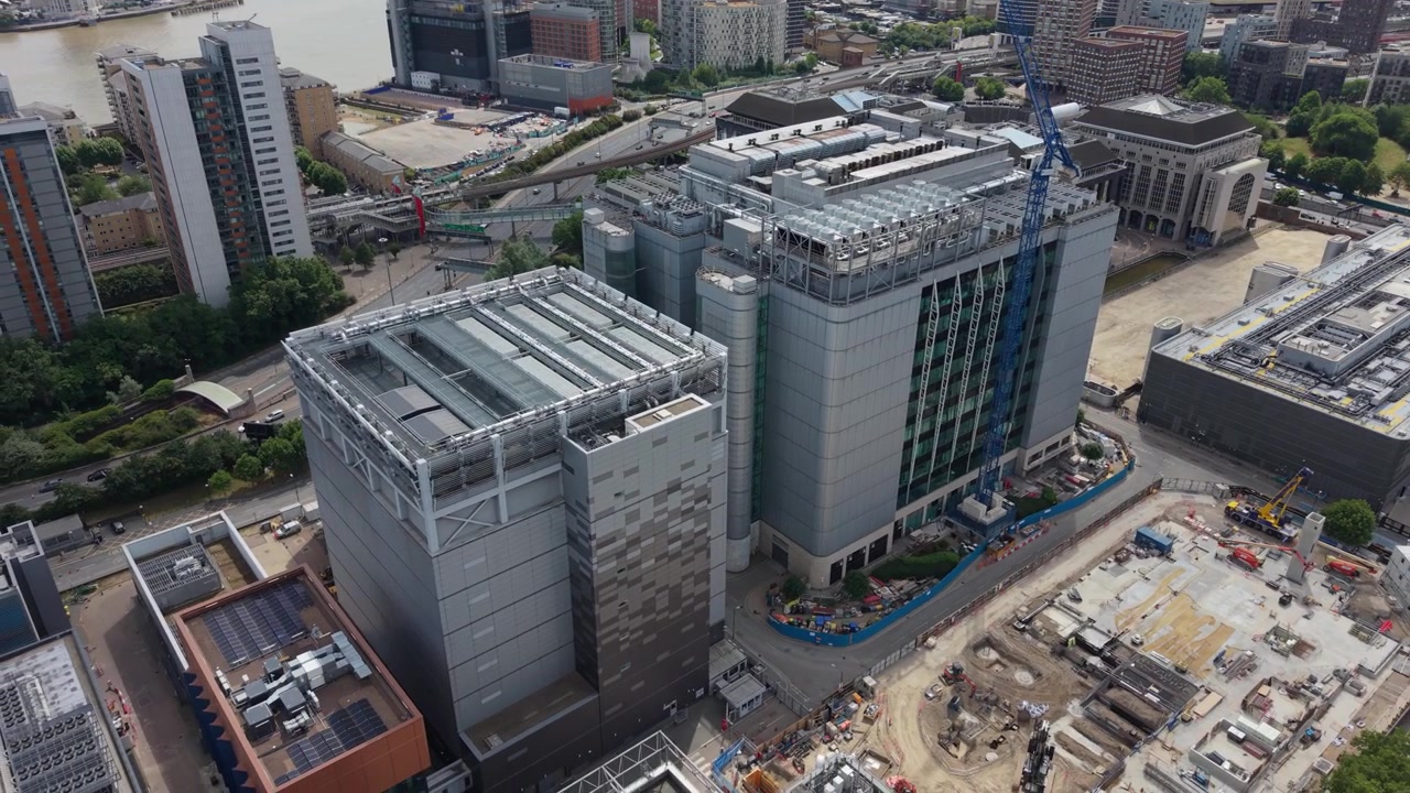 Vuelo de dron sobre una gran instalación de centro de datos en construcción en Londres, Reino Unido. Esta toma diurna captura la extensa actividad de construcción y el moderno paisaje urbano a lo largo del río Támesis.