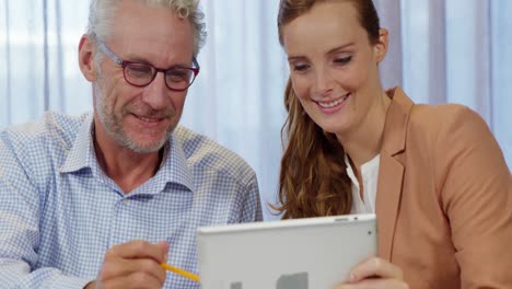 mujer de negocios y compañero de trabajo discutiendo sobre una tableta digital
