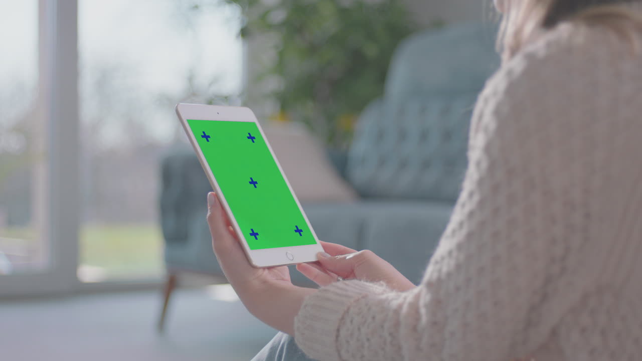 una mujer joven viendo una película en una tableta.